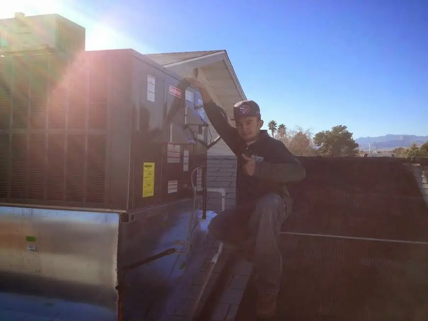 HVAC technician performing Boiler Repair on a rooftop unit in St. Albans